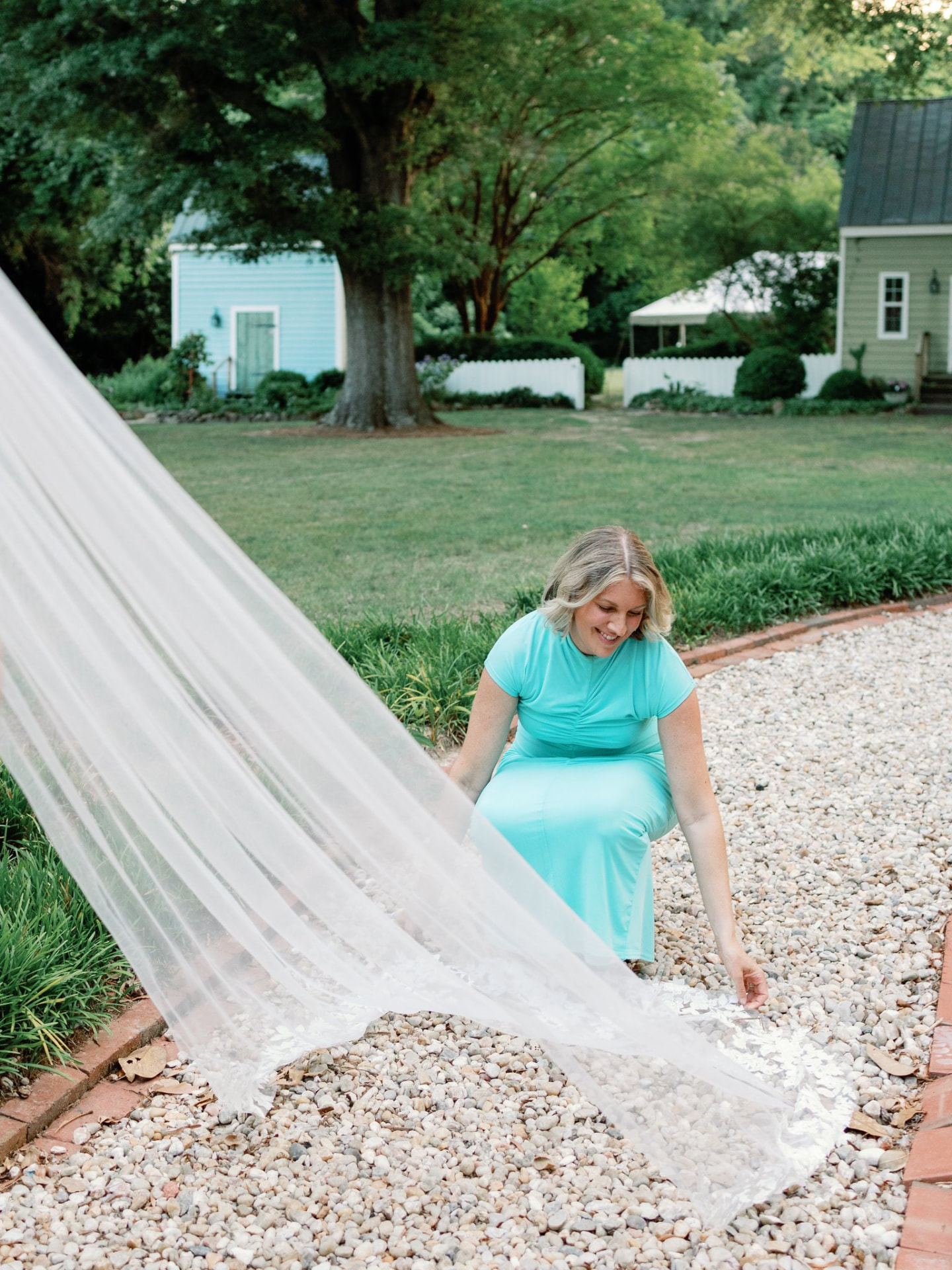 Sara Brosious in a garden setting with a flowing handmade lace veil