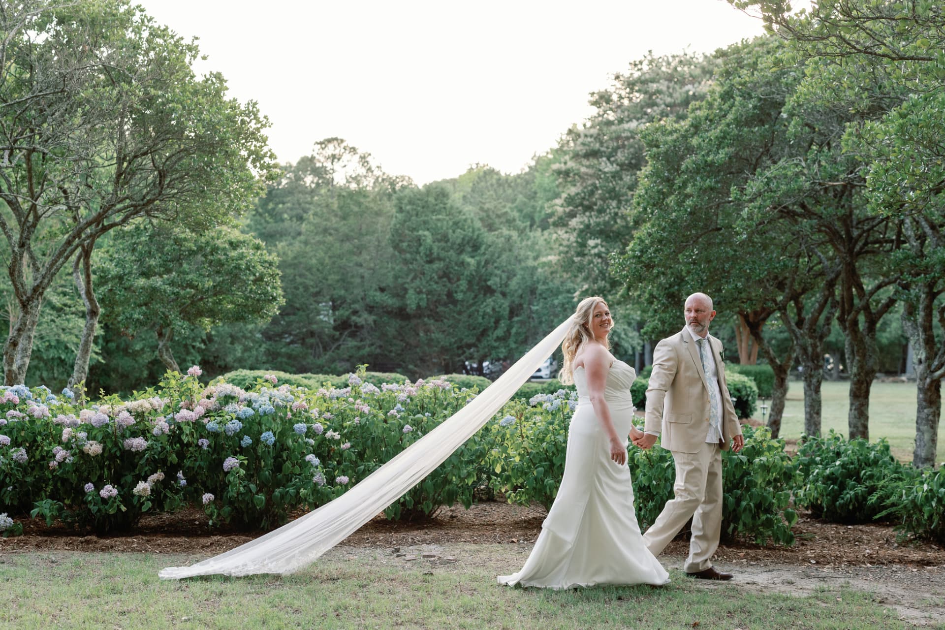 Bride's long custom veil streaming in the breeze