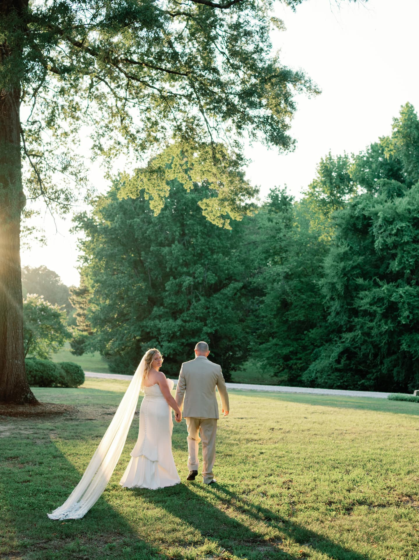 Bride glancing back, lace-edged cathedral veil trailing behind